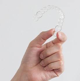 Closeup of patient holding clear aligner