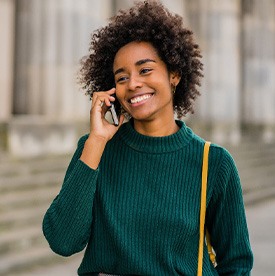Woman smiling while talking on phone outside
