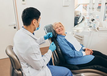 Woman in the dental chair talking to her dentist