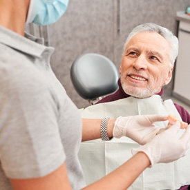 Older man listening as his dentist talks about dentures