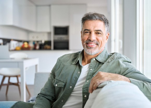Man smiling while relaxing on couch