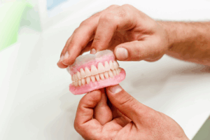 a close-up of a person holding their dentures